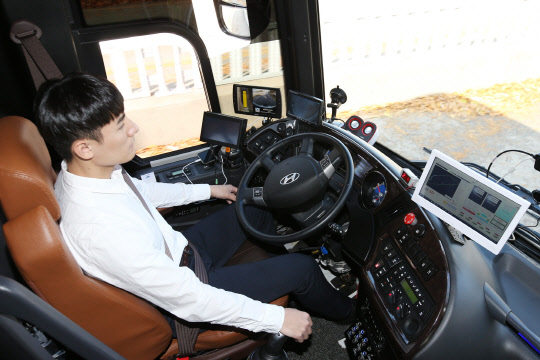 11일 인천국제공항 제1터미널에서 KT 자율주행 버스를 탑승한 직원이 양손을 놓고 차량으로 전달되는 신호를 확인하고 있다. 이날 KT 자율주행 버스는 앞차와 신호 교차로를 자동으로 인식해 속도를 줄이고 장애물을 피해 차선을 변경하는 등 인천국제공항 제1터미널 2.2Km 구간을 안정적으로 주행하는 데 성공했다.                                                                                                                               <KT 제공>